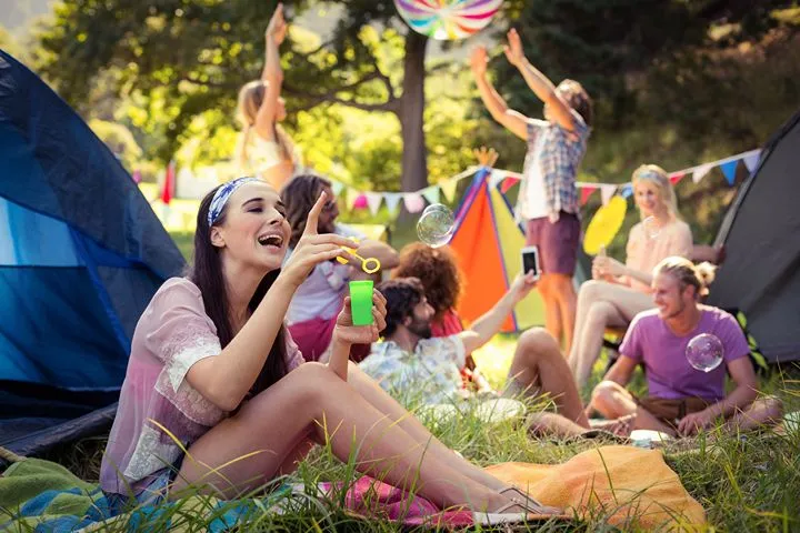 Festival goers at a campsite area enjoying a boutique outdoor festival