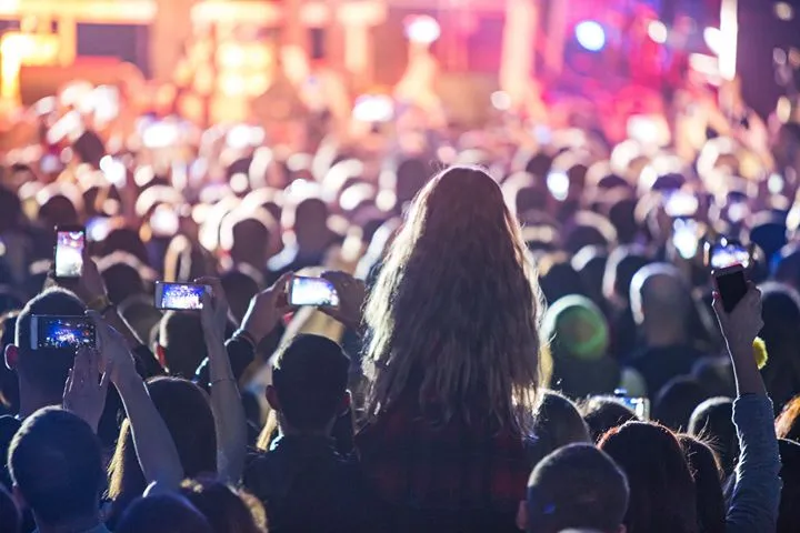 Festival crowd with phones raised at a night concert